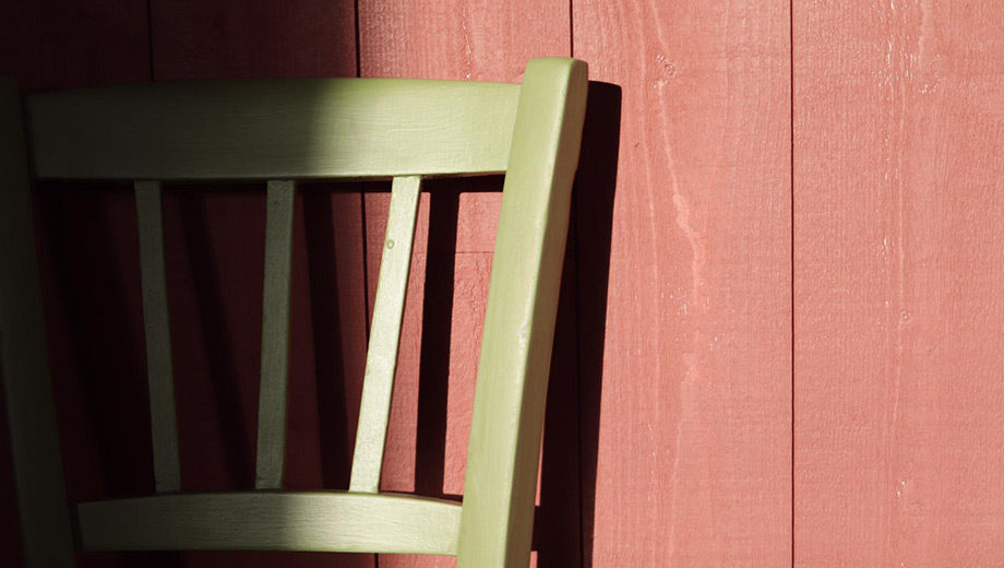 Chaise adossé à un mur en bois rouge